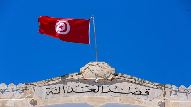 علم تونس يرفرف فوق واجهة حجرية كتب عليها "قصر العدالة"، صورة أرشيفية