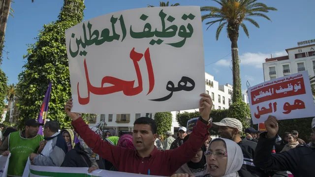 محتج يرفع لافتة مكتوبا عليها توظيف المعطلين هو الحل خلال وقفة سابقة في شارع محمد الخامس بالرباط، صورة أرشيفية