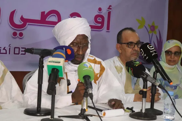 متحدثون على منصة مؤتمر توعوي أمام لافتة حملة أكتوبر الوردي