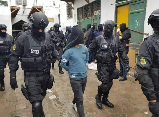 عناصر من المديرية العامة لمراقبة التراب الوطني يقتادون موقوفا مغطى الرأس خلال عملية أمنية سابقة