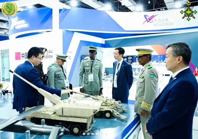 ضباط يطلعون على مجسمات مدرعات في جناح بمعرض دولي للدفاع