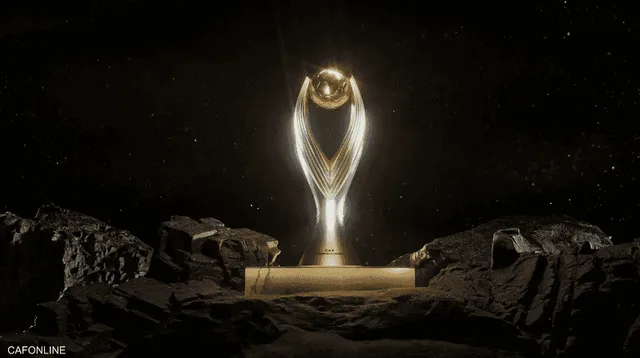 مجسم ذهبي لكأس دوري أبطال إفريقيا الجديدة على قاعدة وسط صخور في خلفية داكنة، صورة أرشيفية