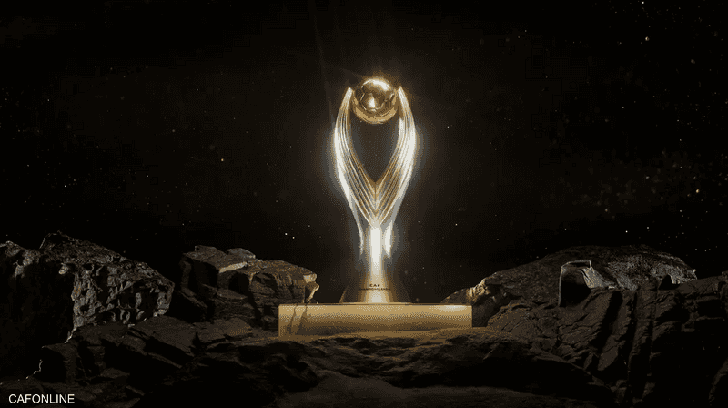 مجسم ذهبي لكأس دوري أبطال إفريقيا الجديدة على قاعدة وسط صخور في خلفية داكنة، صورة أرشيفية